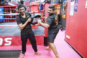 Coach Karthick and Coach Kumar posing goofily in the King of Strength gym.