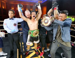 Muhamad Ridhwan celebrating victory with raised arms in the boxing ring