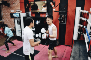 Student receiving expert guidance from a KOS coach during punch practice.