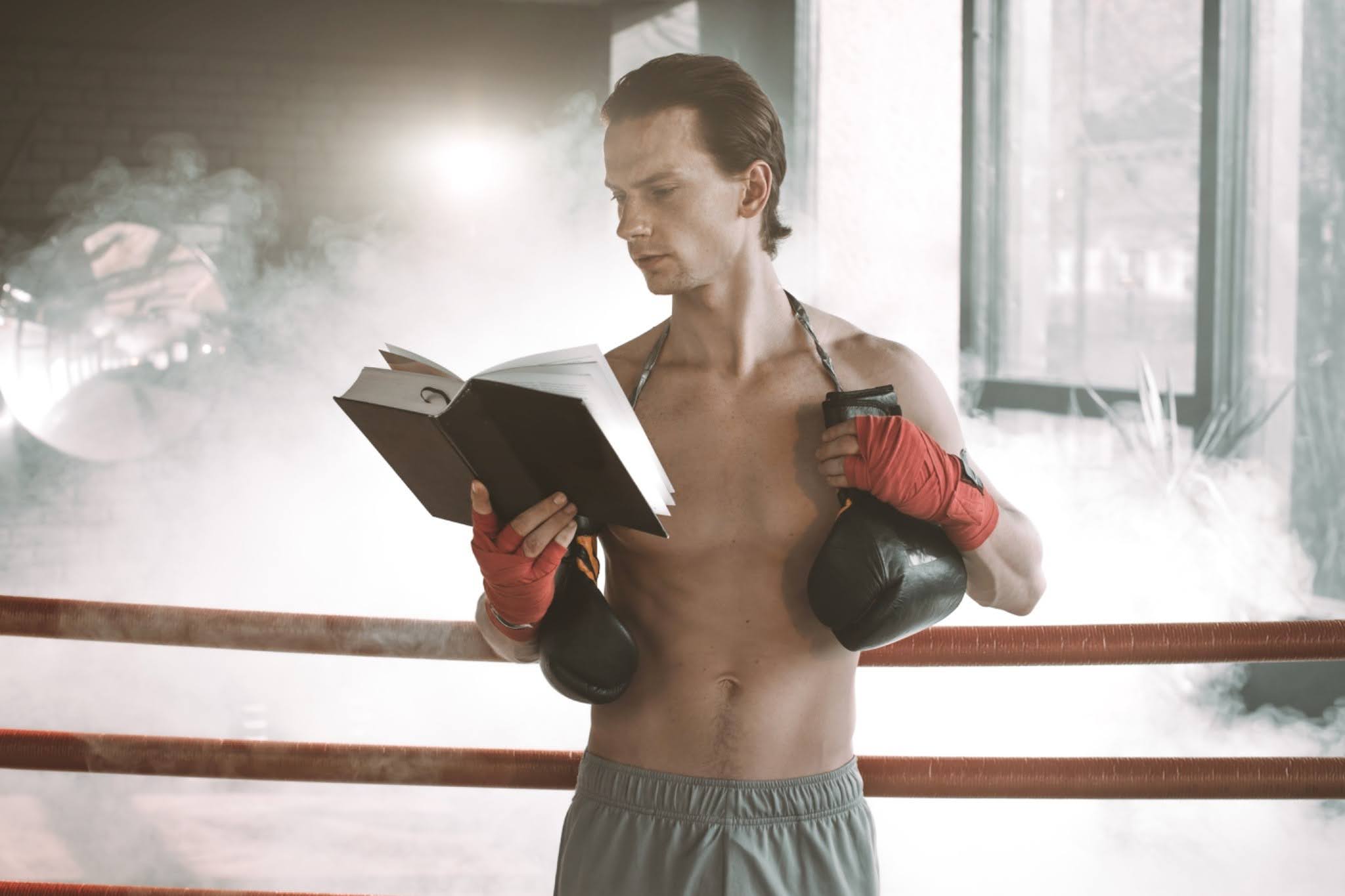 boxer reading a book inside boxing ring