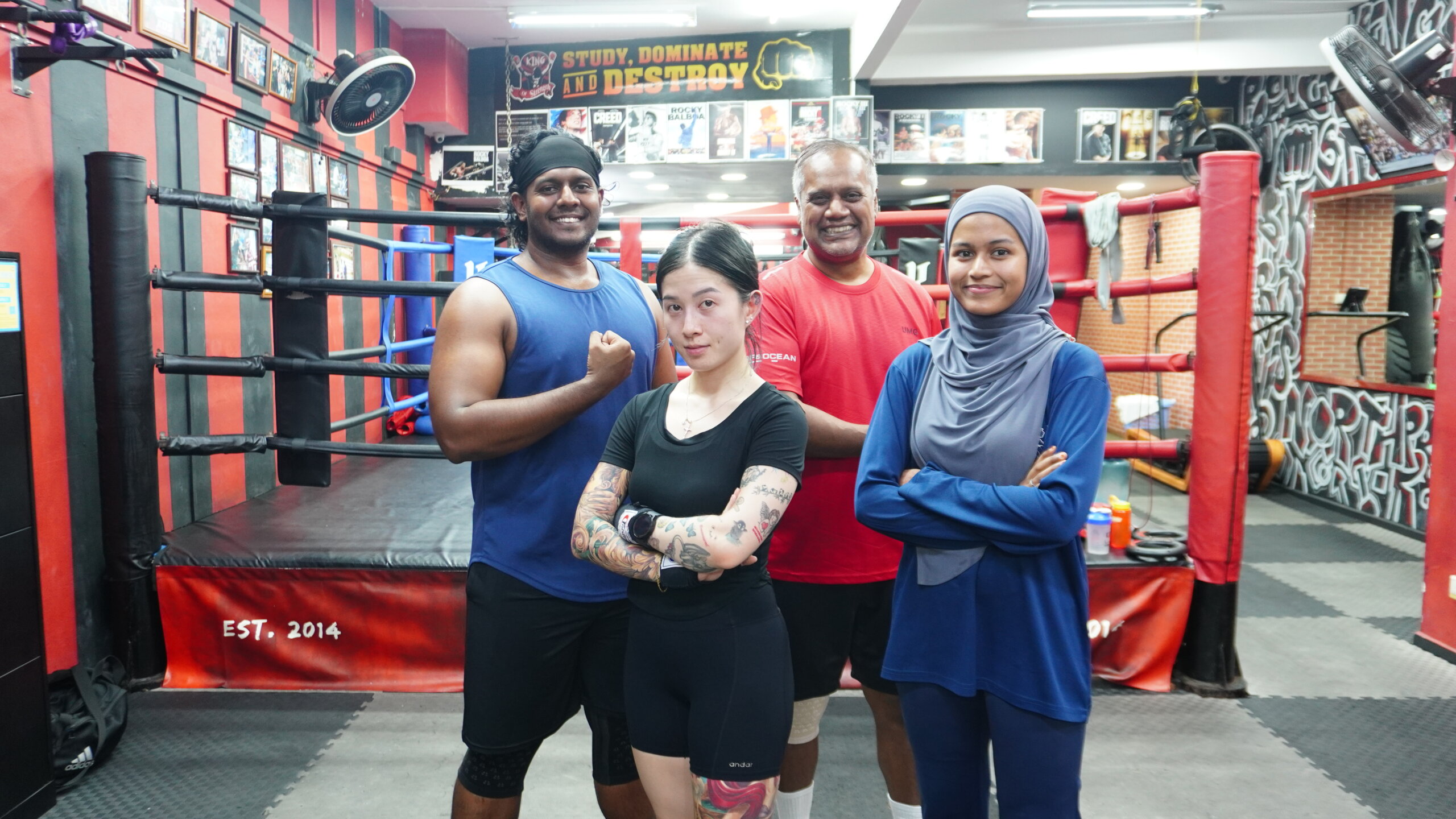 ladies and boxing coaches posing at a boxing gym