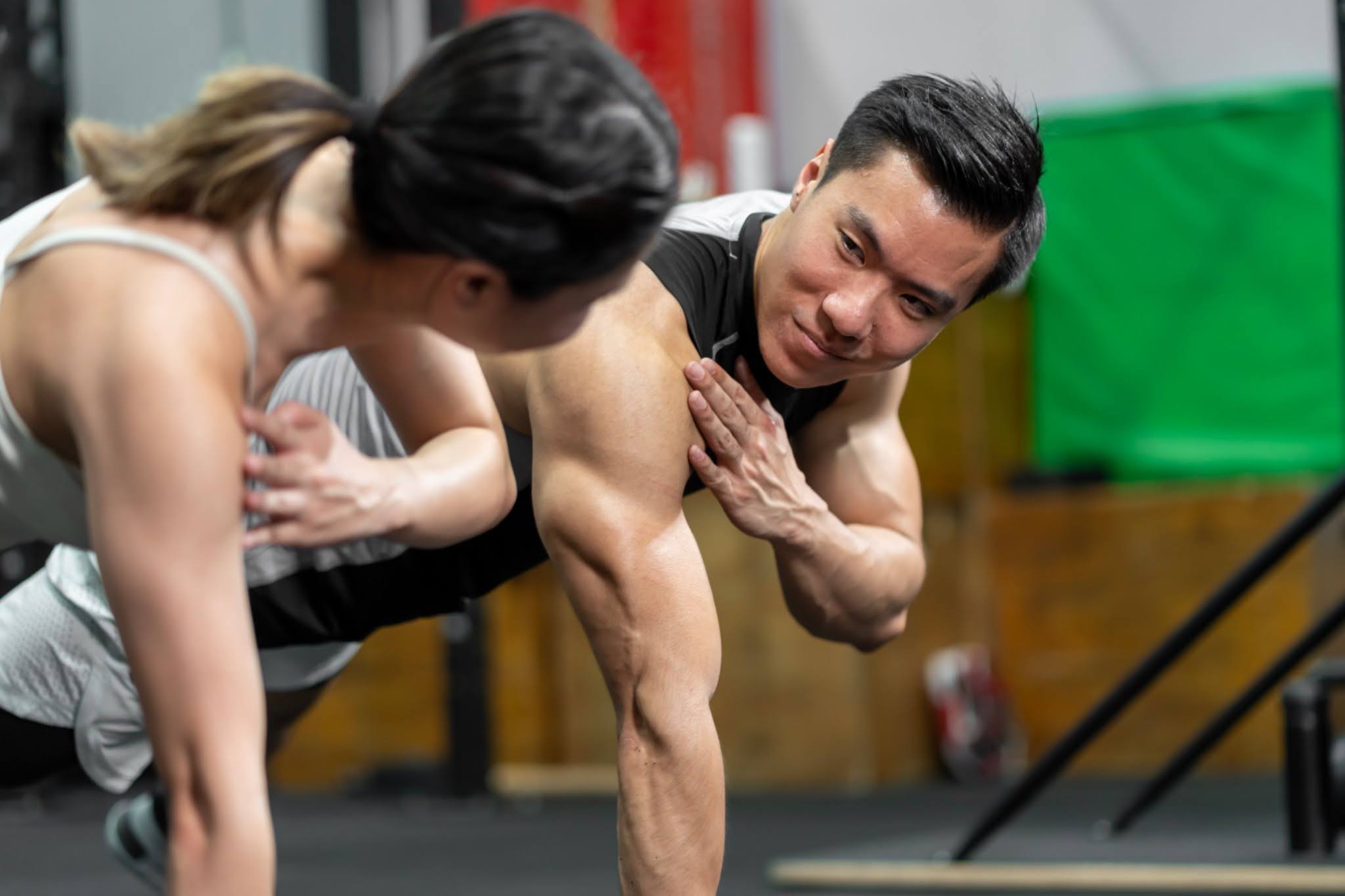 man doing push up with trainer assistance