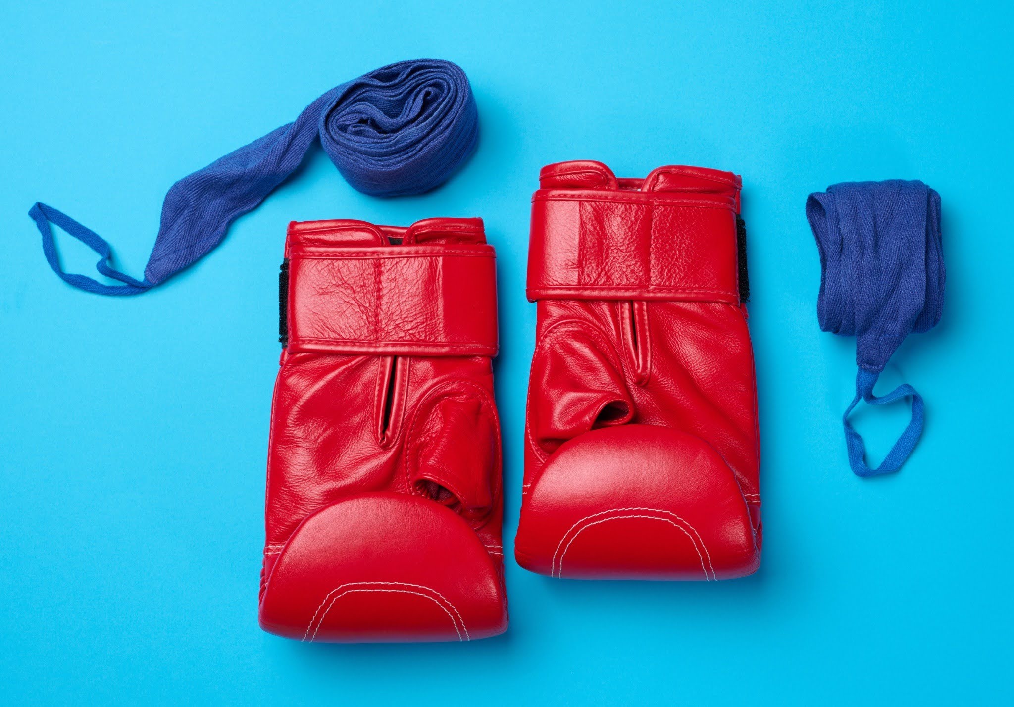 red boxing gloves with blue hand wraps